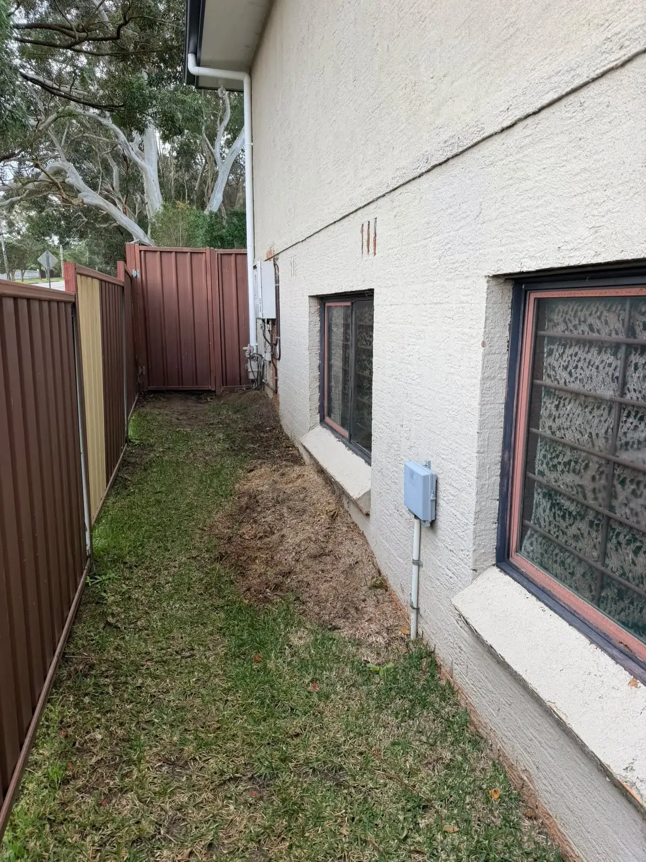 Before: the side of the house where the tank now sits, Bateau Bay.