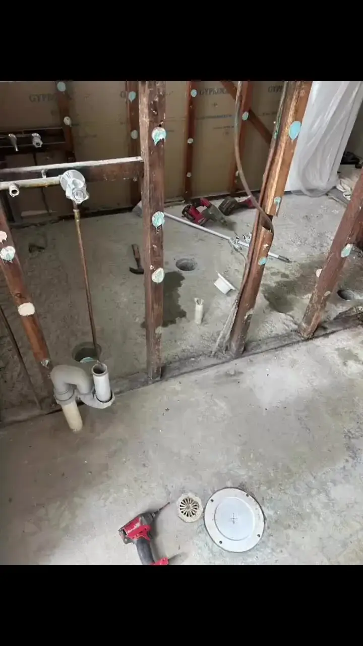 Bathroom strip-out: wastes, floor waste and mixer on a concrete slab
