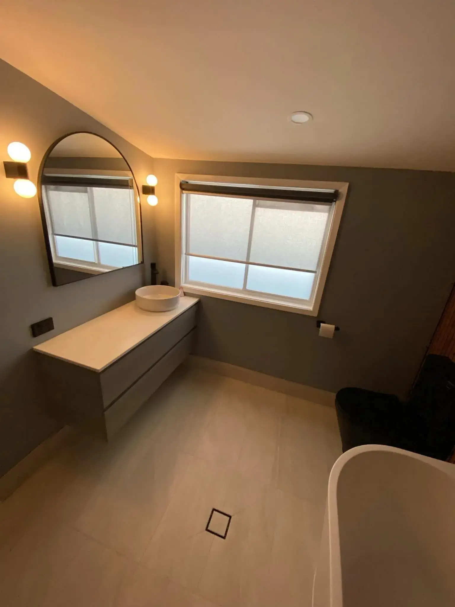Floating vanity, vessel basin and arched mirror.