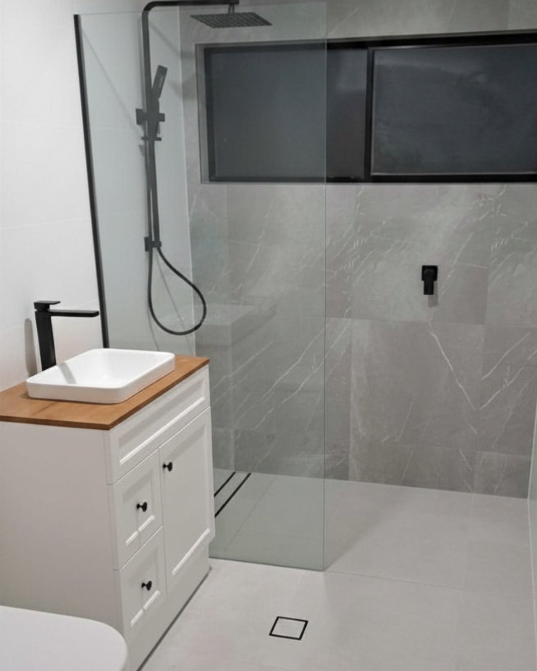 Glass shower, black rail and timber-top vanity.