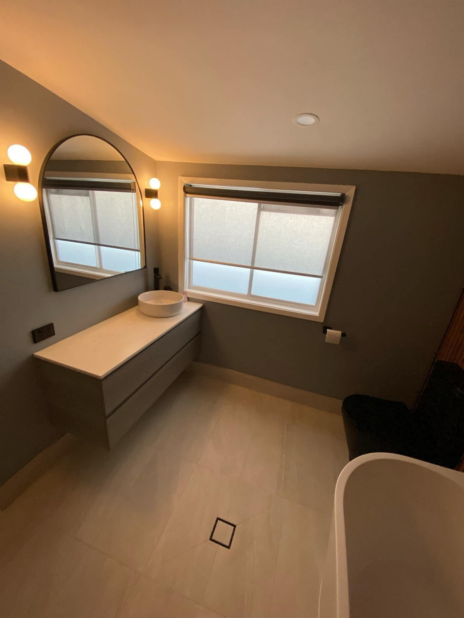 Floating vanity, vessel basin and arched mirror.