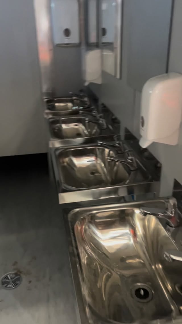 Stainless troughs and tapware in a site amenities donga