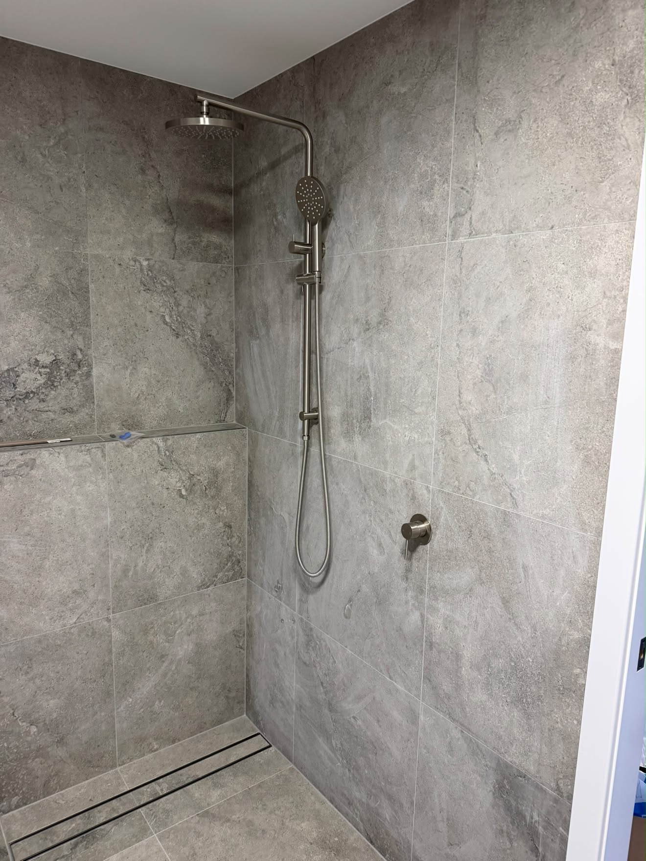 Finished shower, Lake Munmorah: stone-look tile, rain head and linear drain.