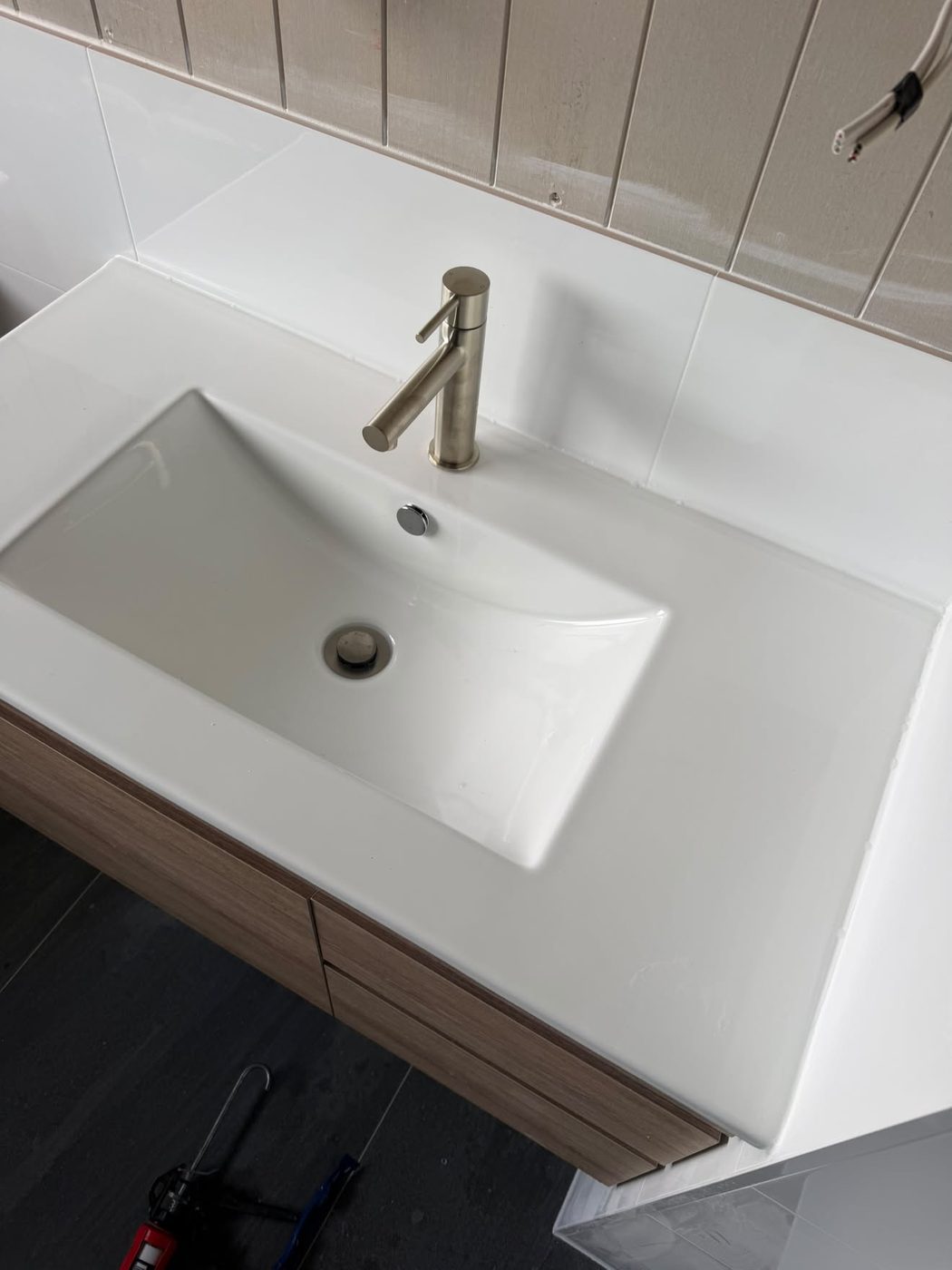 Vanity basin and brushed tapware going on at fit-off.
