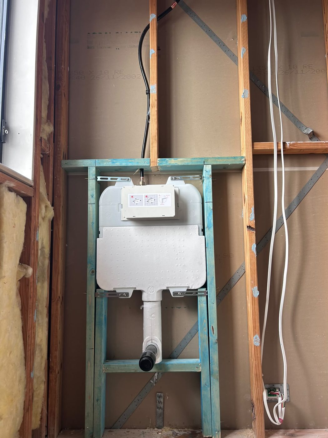 In-wall cistern frame fixed into a stud wall before the sheets go on.