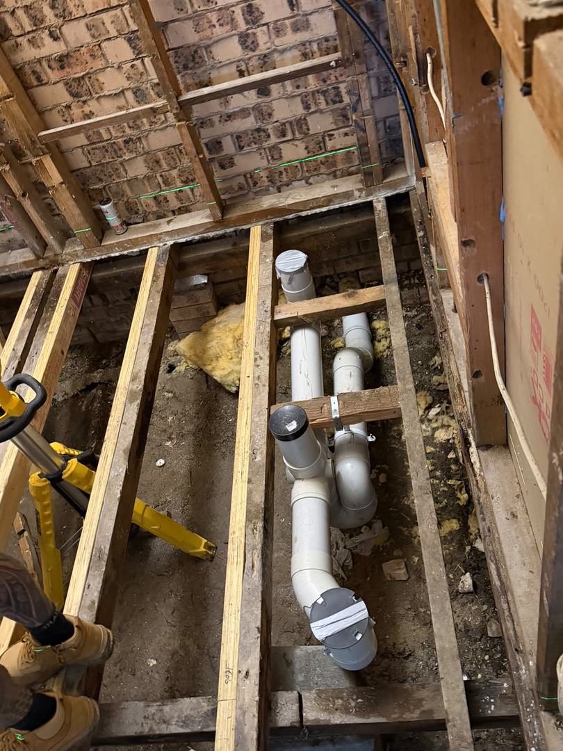 Drainage rough-in through the sub-floor of an older brick home.