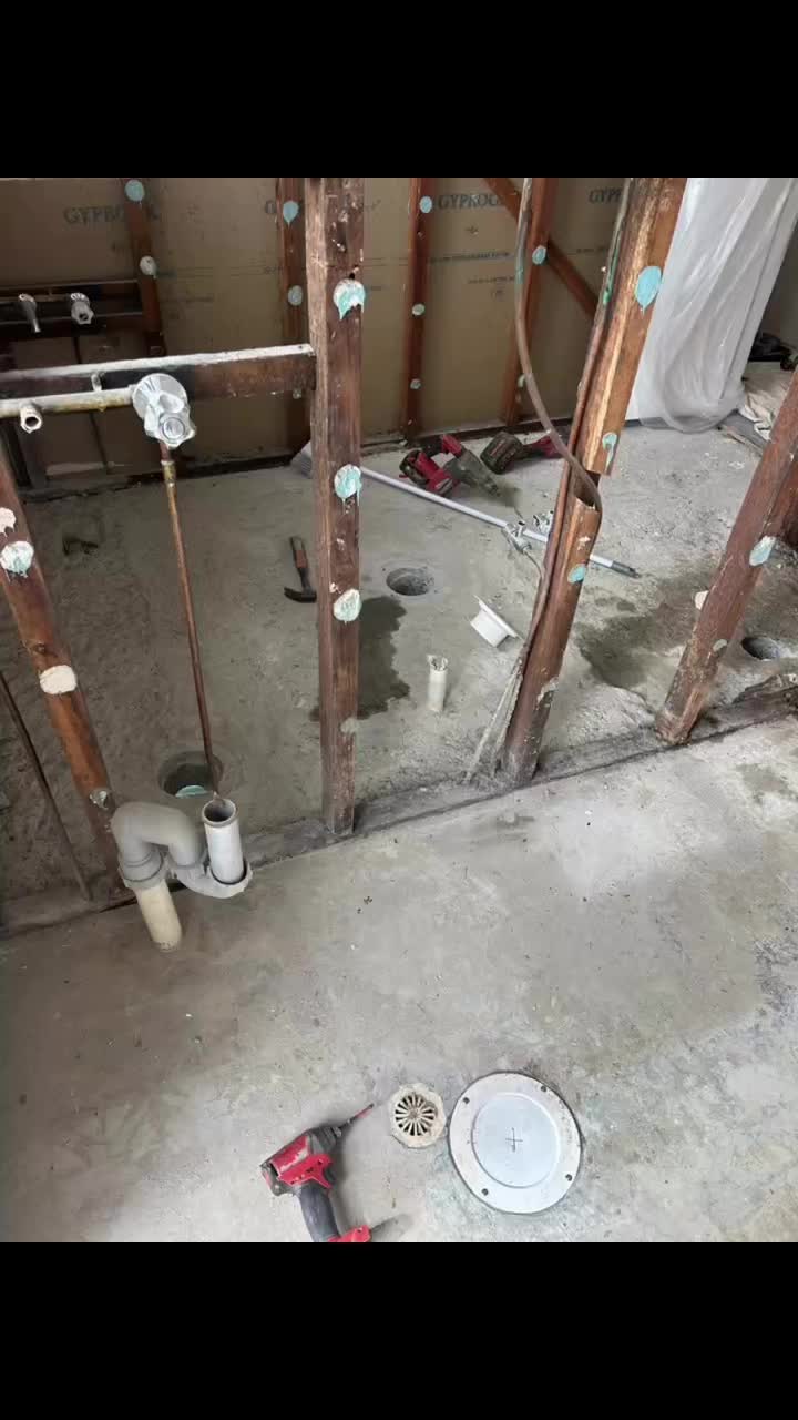Bathroom strip-out: wastes, floor waste and mixer on a concrete slab